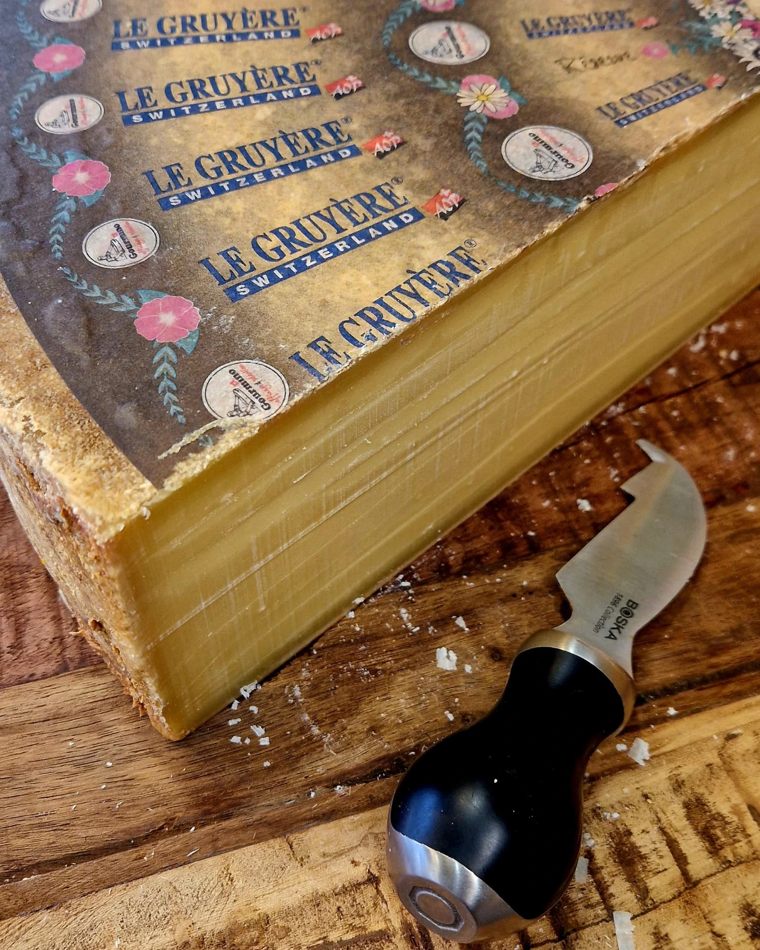 Ett stycke Le Gruyère på skärbrädan med ostkniv bredvid